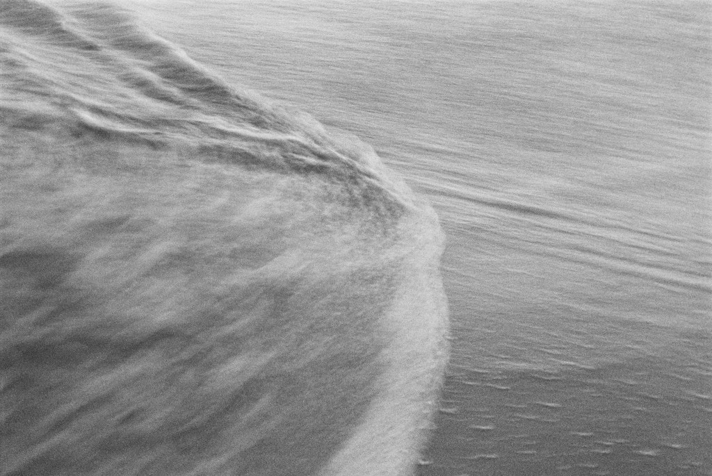 Ocean water washes over the sand on the Southern California coastline.